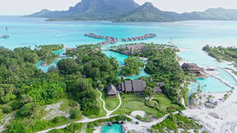 bora bora, french polynesia. drone shot of luxury resort, overwater bungalows and main island with volcanic hills