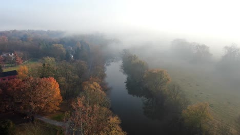 Hermosa-Antena-Cinematográfica-De-árboles-De-Otoño-Junto-A-Un-Río-Tranquilo-Durante-La-Mañana-Nublada