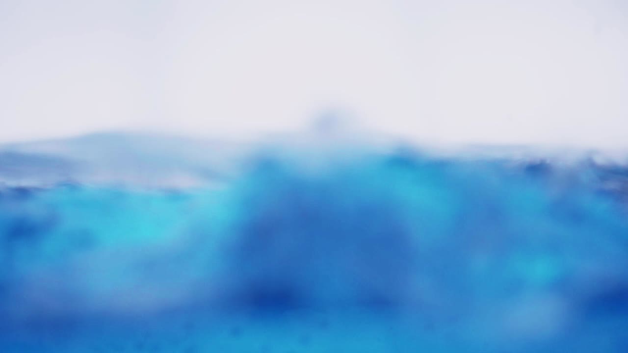 la superficie del agua limpia en cámara lenta llena la pantalla con agua salpicando la gota de agua y la superficie líquida ondeando con una burbuja de aire