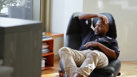 man relaxing on chair in a comfortable home 4k