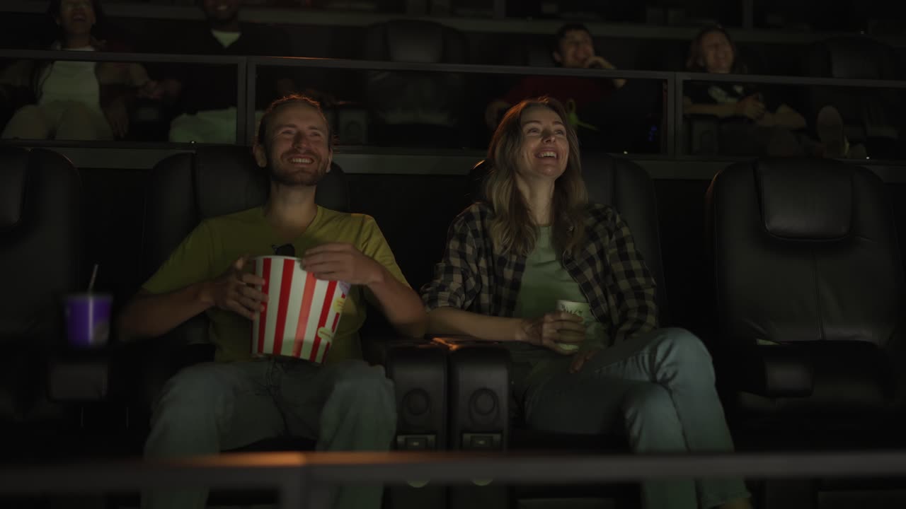 el novio y la novia ven una película de comedia, riendo en voz alta.