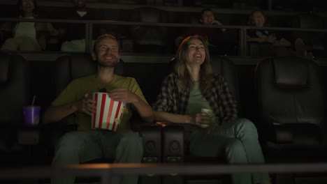 Boyfriend-and-girlfriend-watch-comedy-film,-laughing-loudly