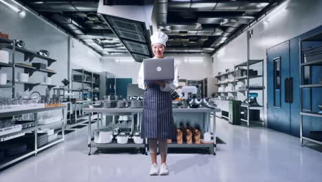 chef feliz usando una computadora portátil en una cocina moderna