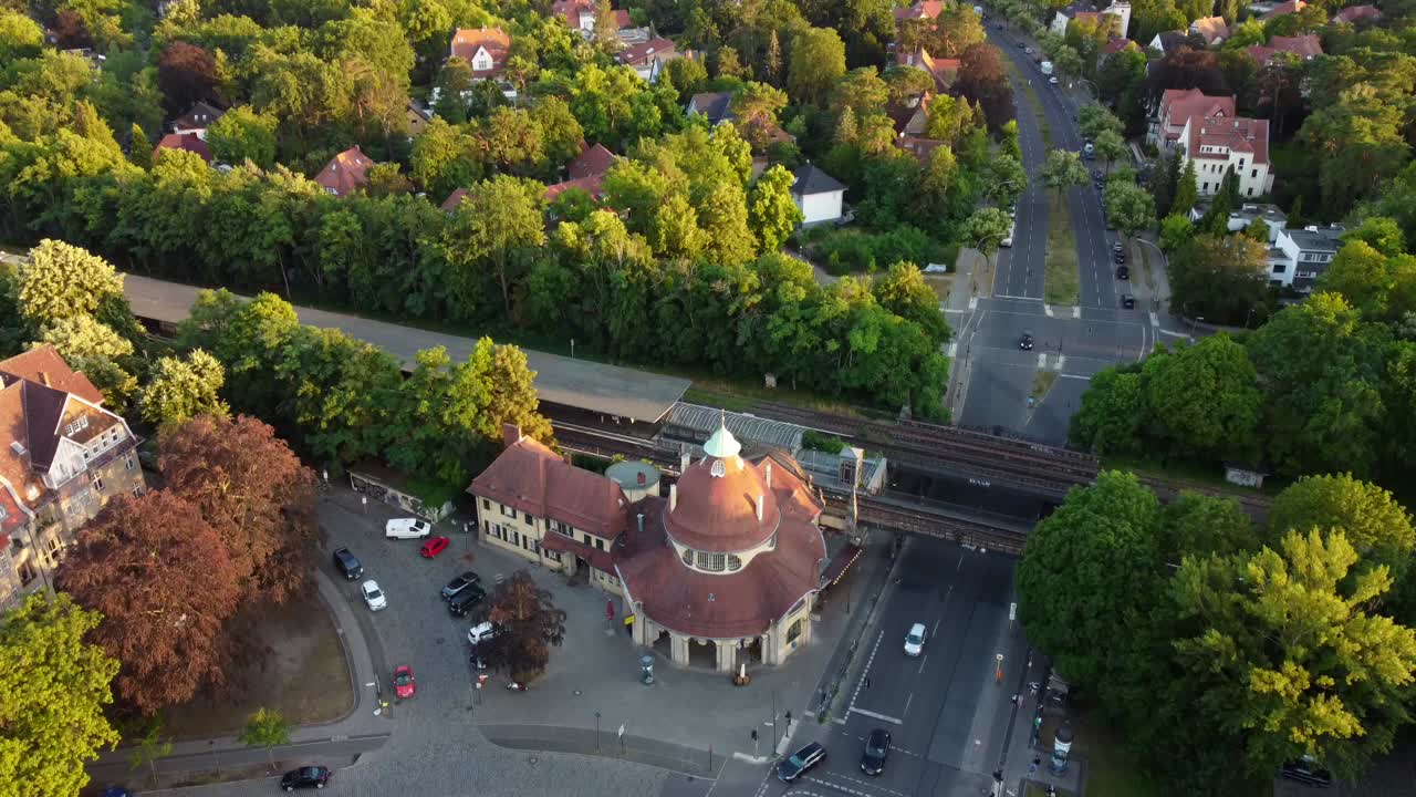 área de villas de la ciudad alrededor de la estación de tren gran vista aérea vuelo inclinación hacia arriba imágenes de drones de mexikoplatz berlín zehlendorf hora dorada verano 2022
