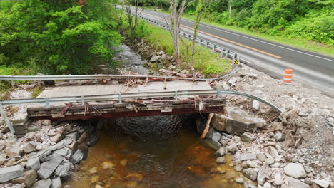 lowering aerial view: close-up of flood-damaged bridge in plymouth notch, vt