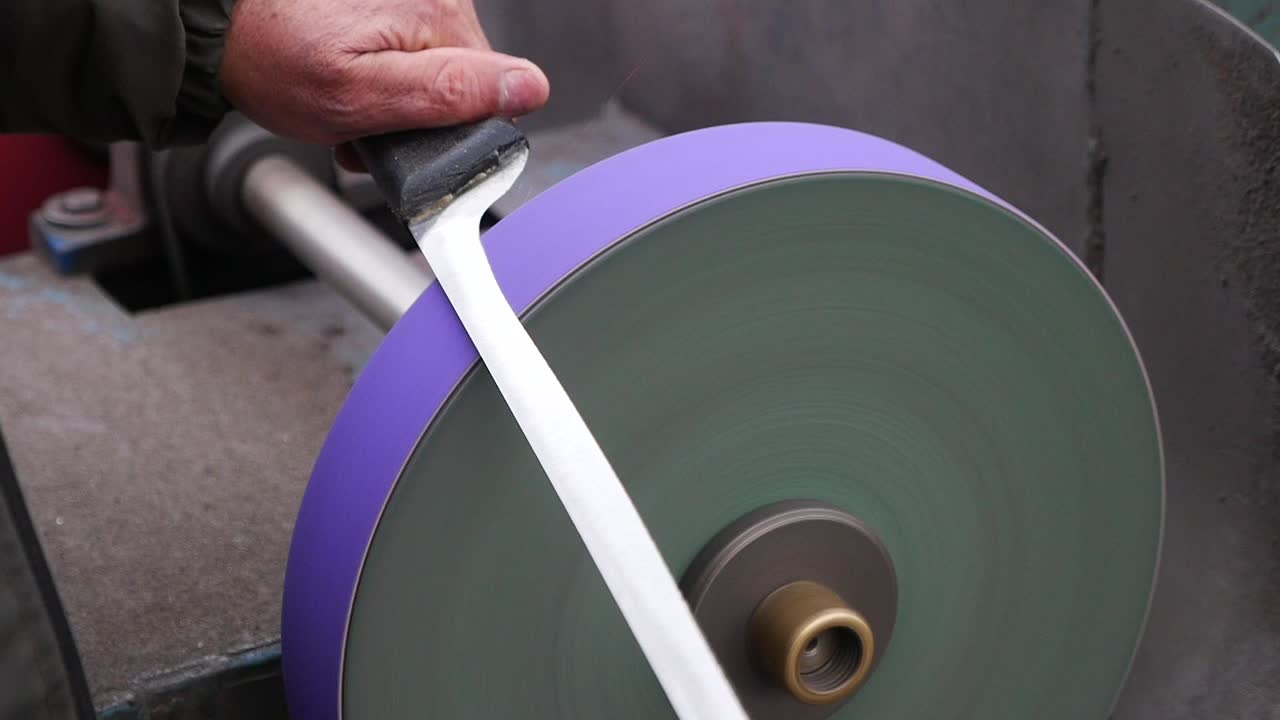 Close-up of a Hand Sharpening a Knife on a Grinding Wheel