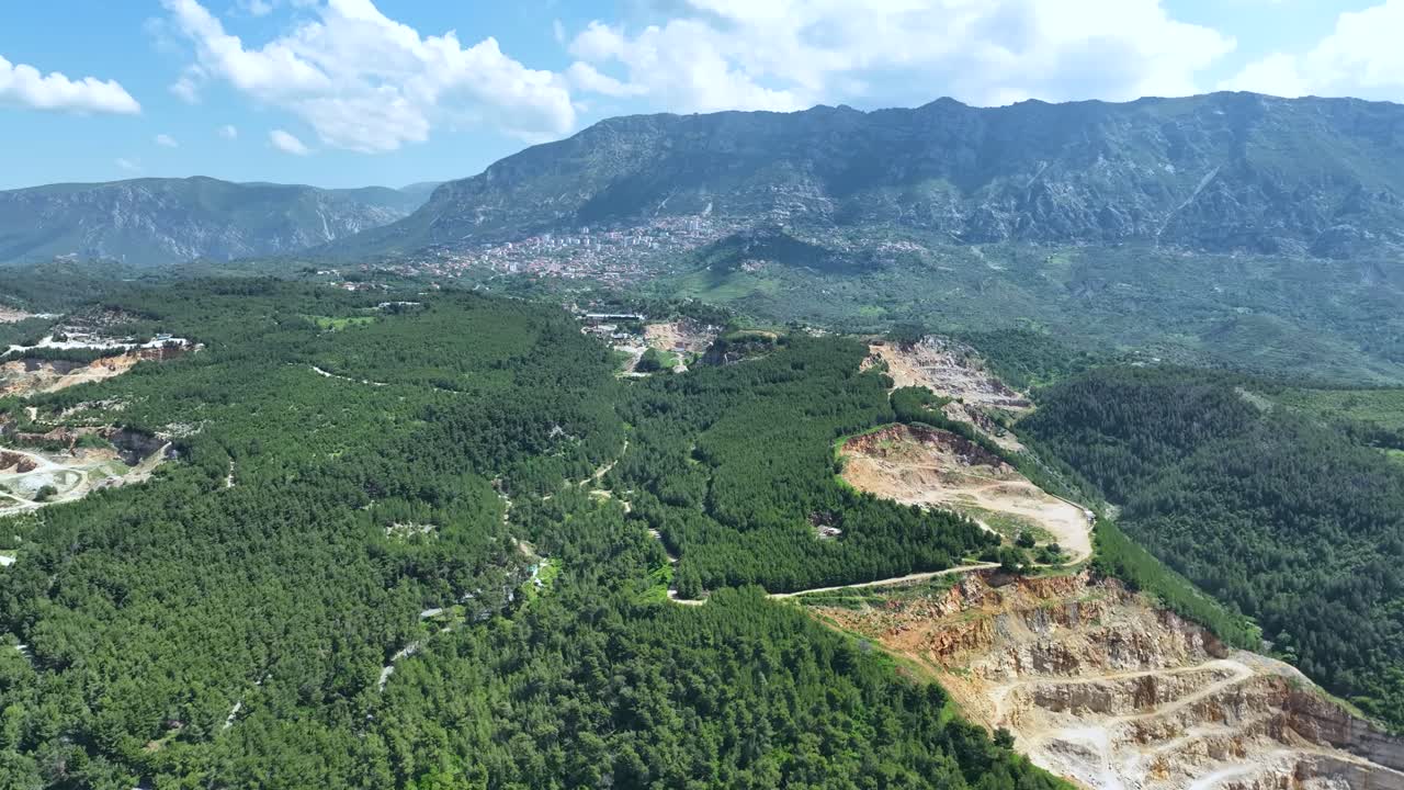 gran cantera en la ladera causando deforestación con la ciudad cercana