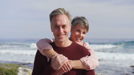 Portrait-of-Caucasian-couple-enjoying-free-time-by-sea-on-sunny-day-