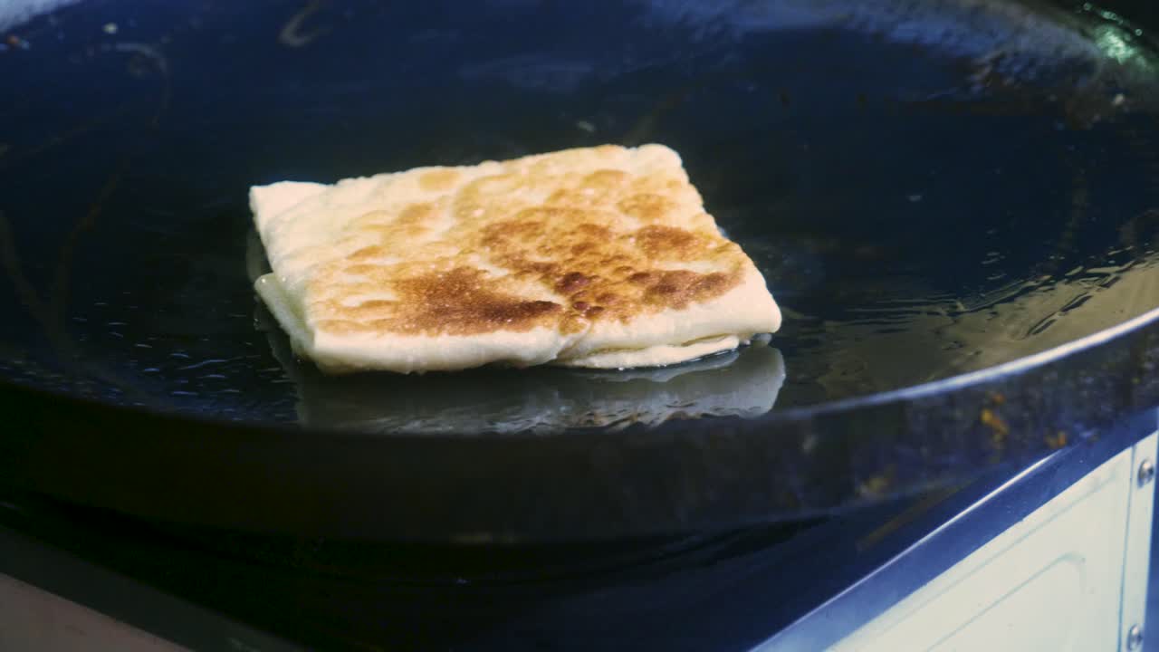 태국의 길거리 시장에서 로티라는 전통적인 태국 디저트를 준비하는 태국 요리사의 4k 영화 요리 영상