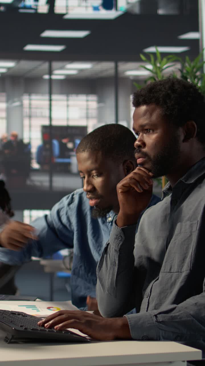 Two African American Businessmen Collaborating on Laptop in Modern Office