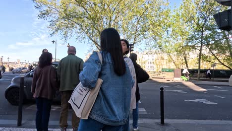 pedestrians waiting to cross a street in paris