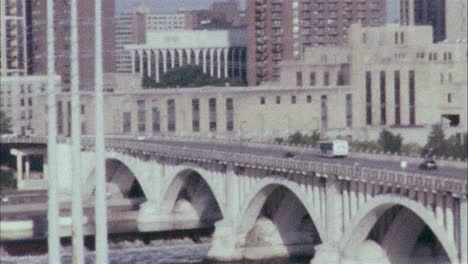 color 16mm film of bus driving over a bridge towards a city