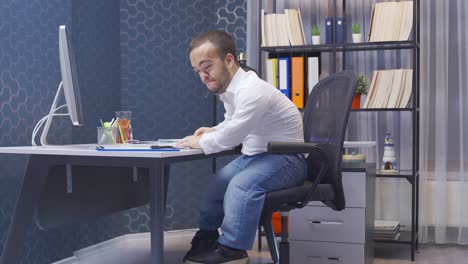 un enano enojado trabajando en la computadora en su oficina.