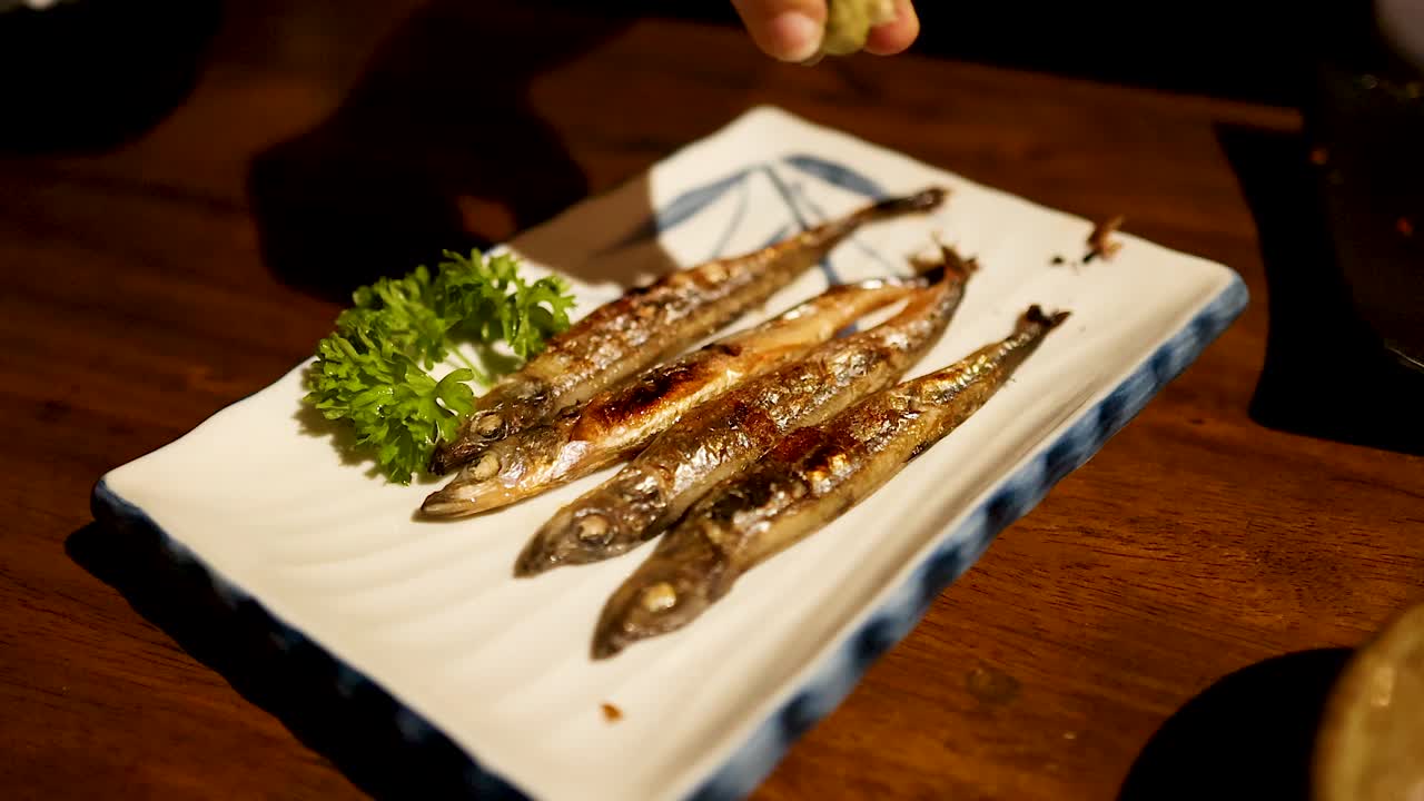 limón exprimido sobre pescado a la parrilla con guarnición