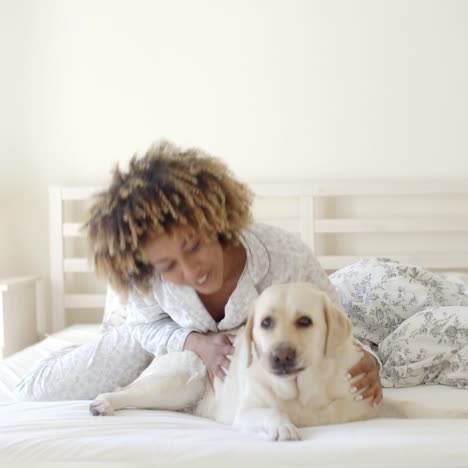 woman is holding a dog on a bed