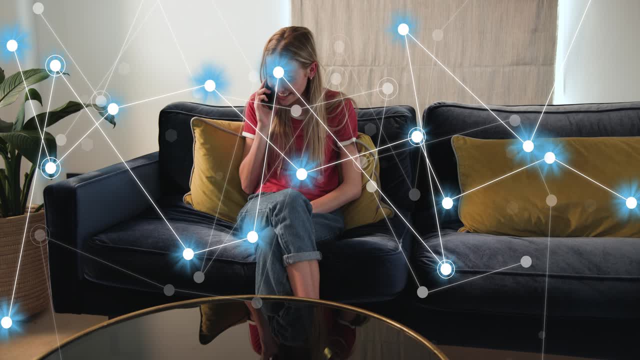 Woman sitting blue sofa talking on phone, causing glowing nodes growing right showing tech net