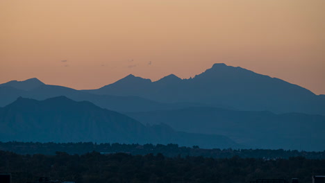 Orange-sky-at-sunset-with-silhouette-view-of-Rocky-Mountains,-timelapse