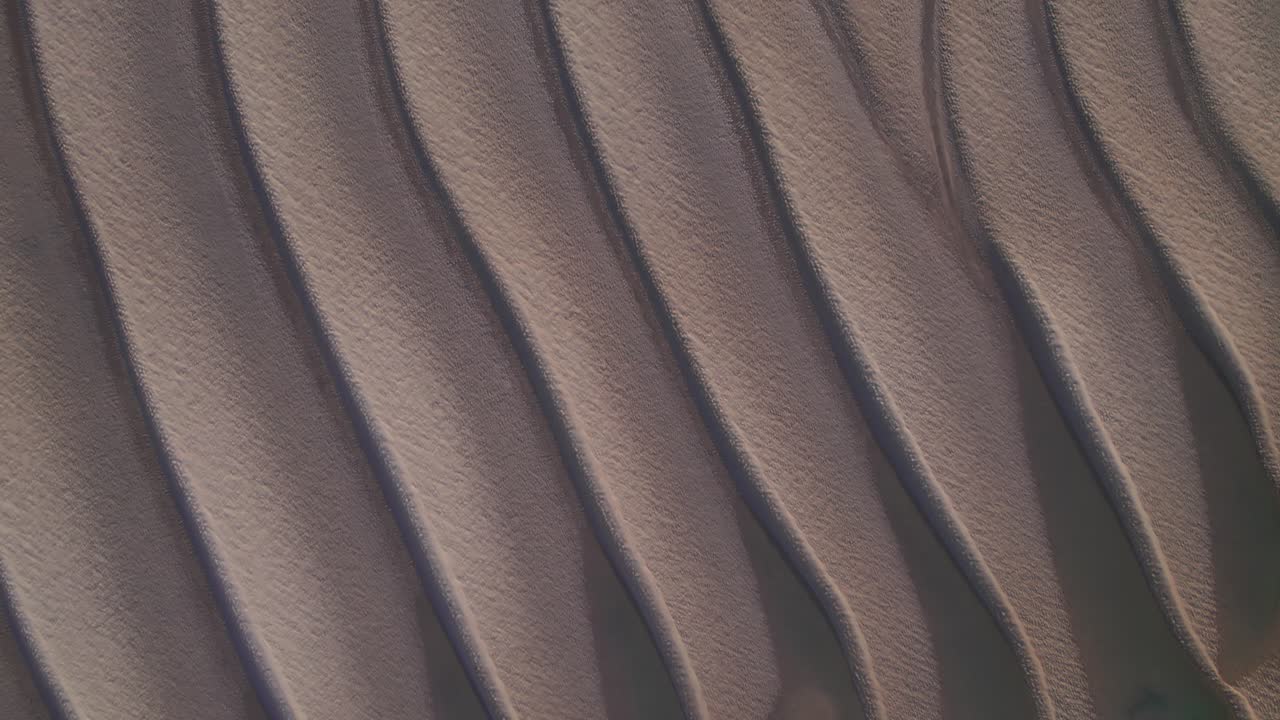 detalle de la formación de arena ondulada en la playa de marea baja