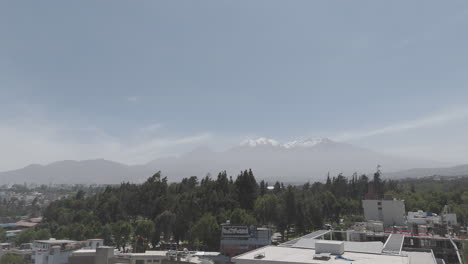 from high to low angle drone shot above arequipa peru on a bright day with some mist with view on the mountains log