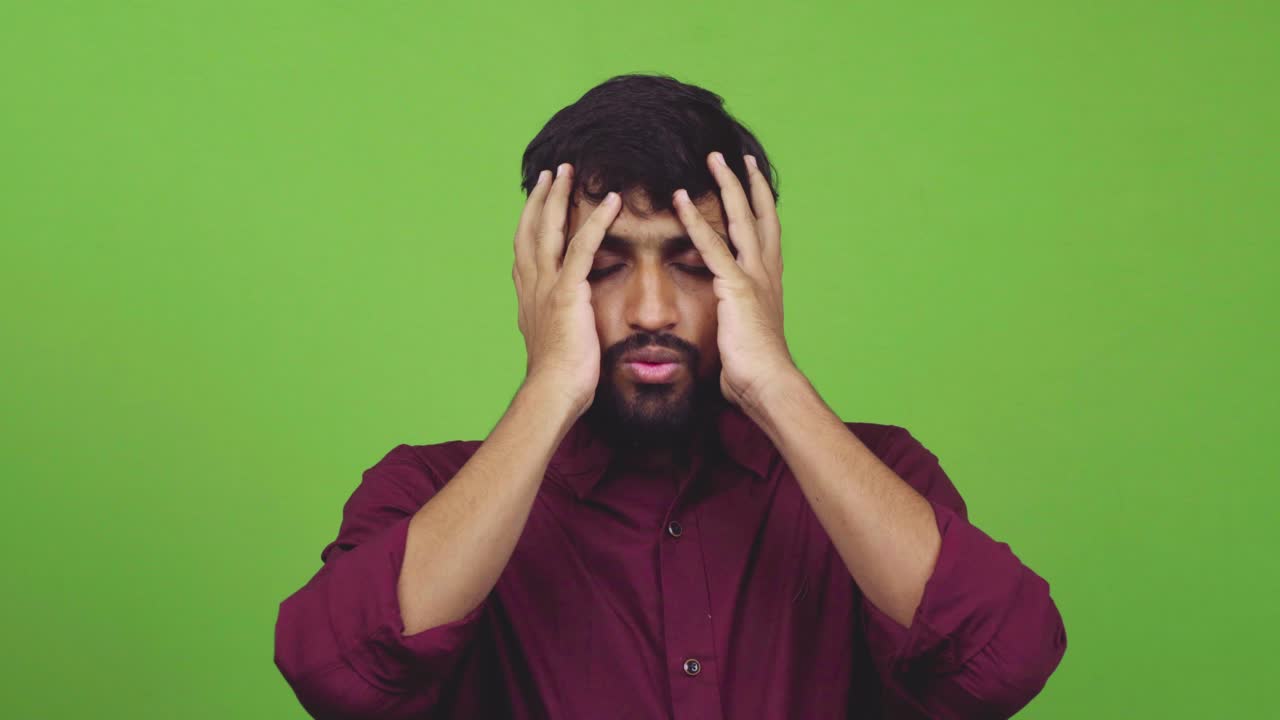 Attractive man finds out bad news and puts his arms on forehead, isolated on green screen