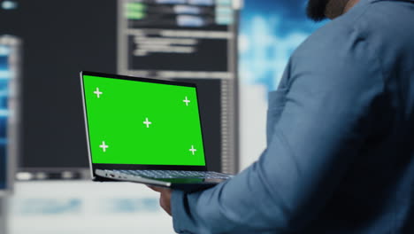 black engineer works on binary code with chroma key on laptop
