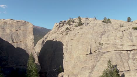 Drone-shot-of-evergreen-trees-sparsely-covering-the-Rocky-Mountains-at-sunset