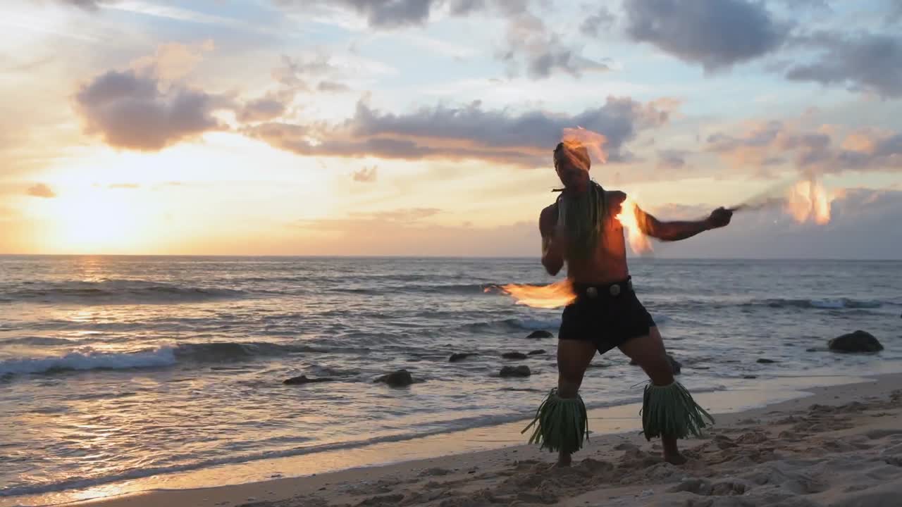 Fire juggler juggling fire sticks in the beach 4k