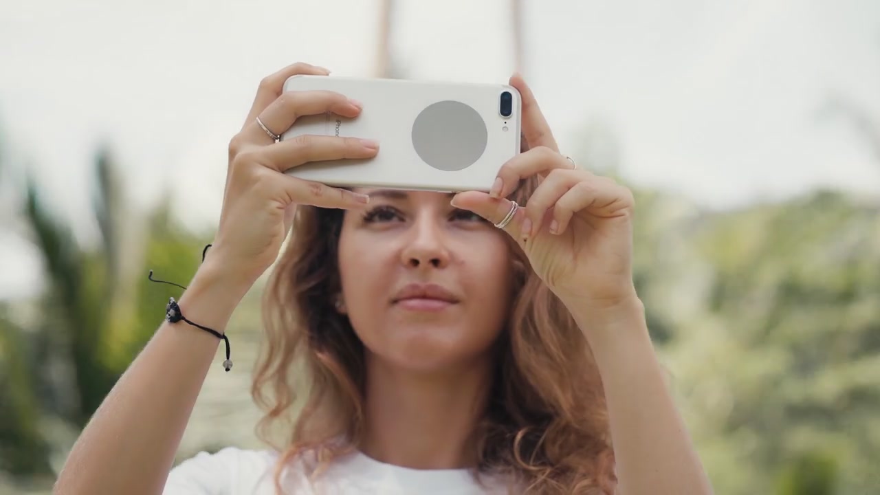 Jovem Mulher Tirando Fotos com Smartphone em Cenário Tropical
