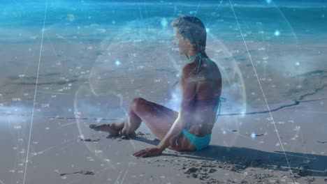Animation-of-digital-globe-and-numbers-over-happy-caucasian-woman-in-bikini-sitting-at-beach