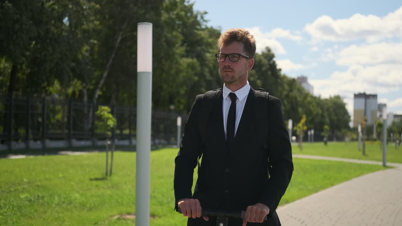 hombre de negocios en un scooter eléctrico en un parque