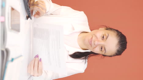 vídeo vertical de la mujer que revisó y firmó el papeleo es feliz y satisfecho.