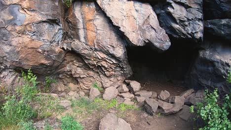 Pan-right-to-a-darkened-cave-entrance