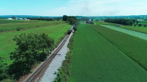 Dampfzug,-Der-An-Einem-Sonnigen-Sommertag-Durch-Amisches-Ackerland-Und-Landschaft-Fährt,-Wie-Von-Der-Drohne-Aus-Gesehen