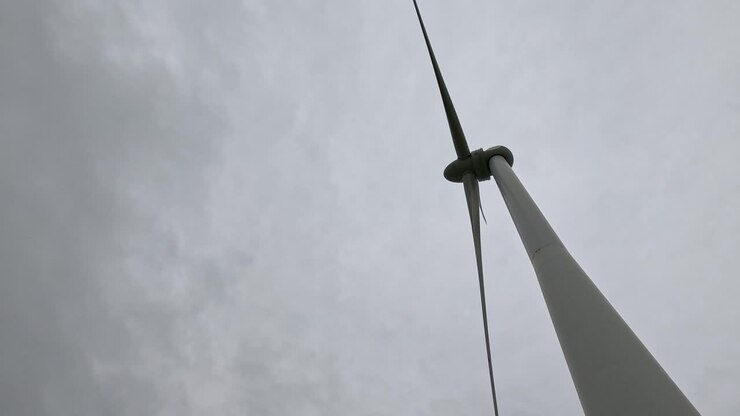 Wind turbine rotating under cloudy sky