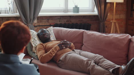 African-American-Man-Lying-on-Couch-during-Therapy-Session-with-Psychologist