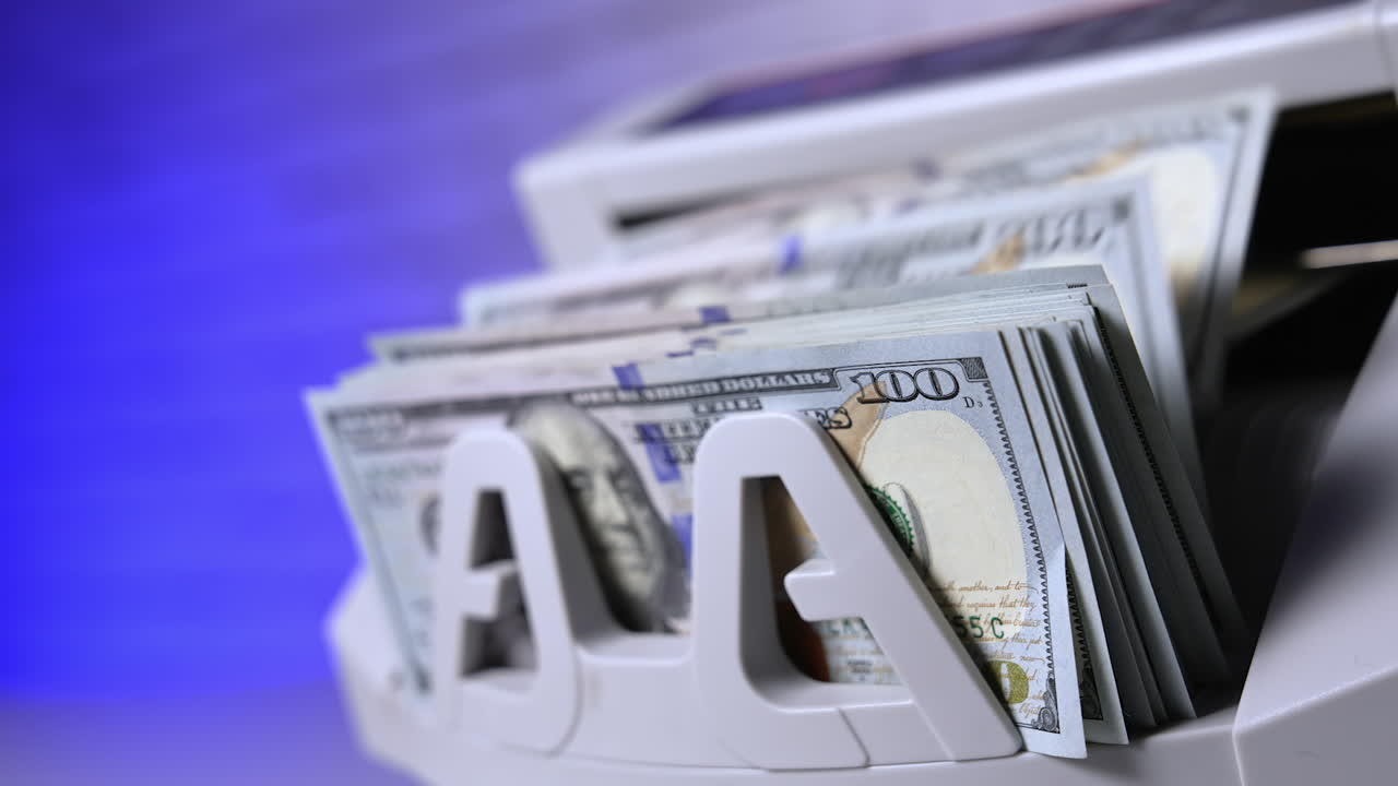 Counting hundred of dollar bills in bank. Financial operation on a modern electronic cash counting machine. Automatic equipment for counting paper money.