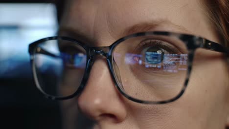 woman's eyes with glasses reflecting digital information