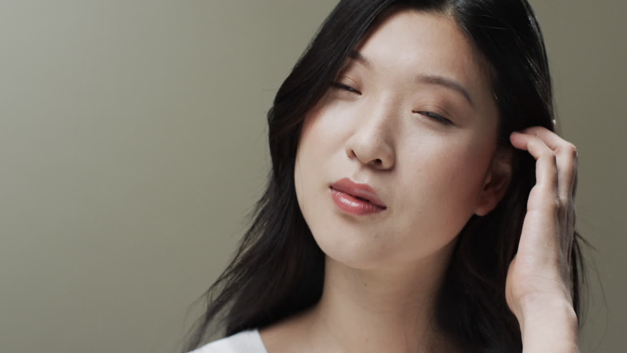 검은 머리카락과 메이크업을 가진 아시아 여성, 머리카락을 만지는, 공간을 복사, 느린 동작