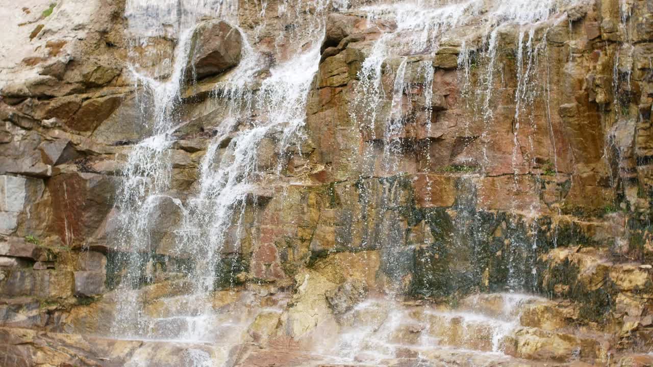 숲 속의 절벽에서 아름다운 폭포: 숲 속에 있는 돌들 사이에서 흐르는 하천, 흐르는 물의 4k 비디오