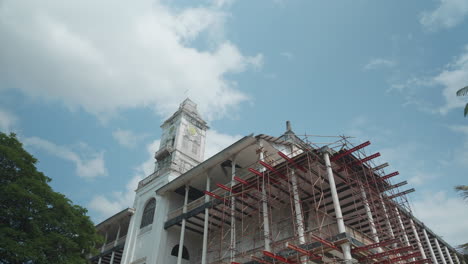 open shot of house of wonders from under a blooming tree in zanzibar stone town