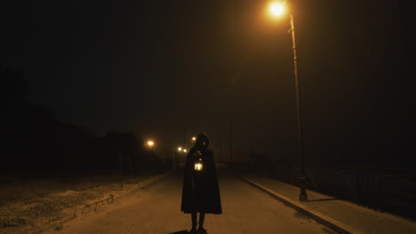 mysterious man with walks walks down street at night on halloween