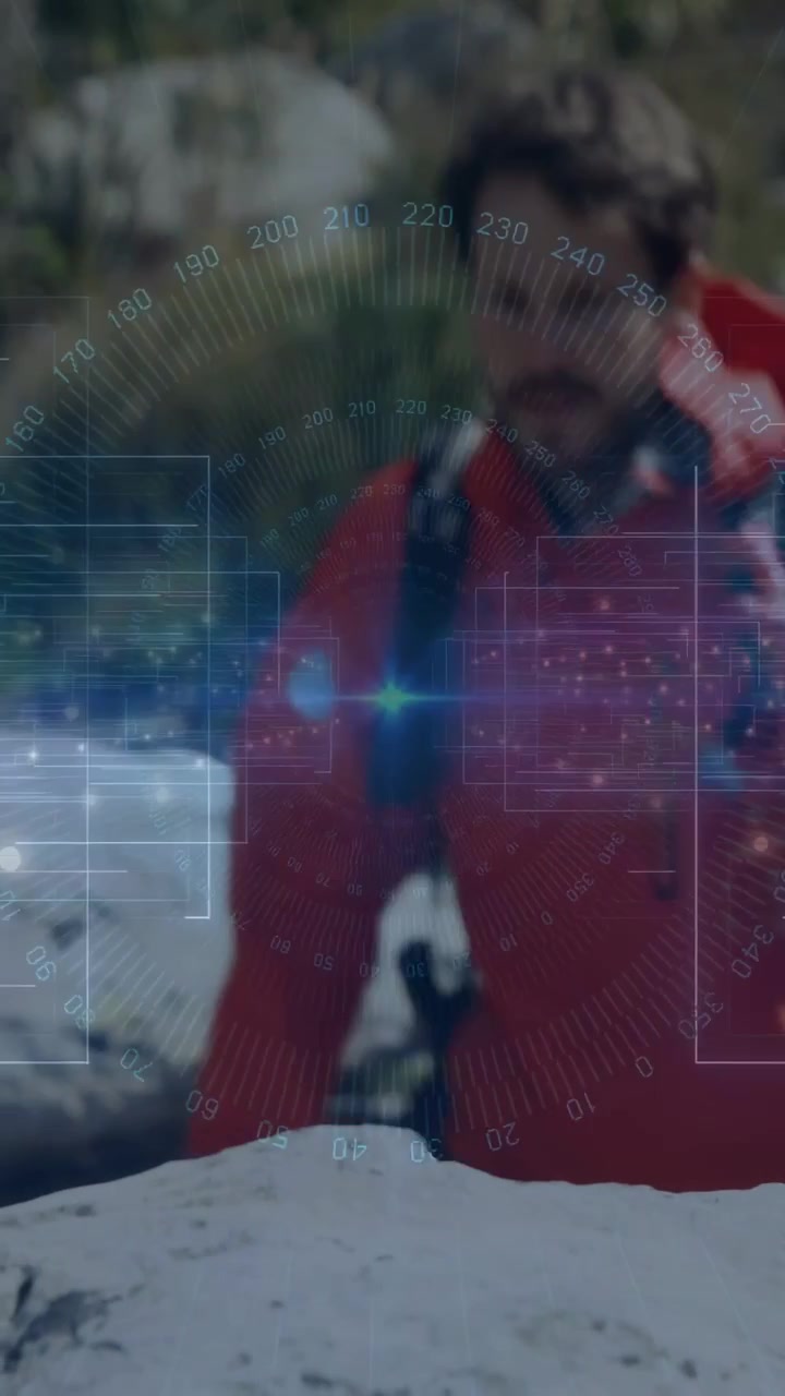 Vertical video: Male hiker walking toward rock reaching and steadying HUD tech overlay tracking him
