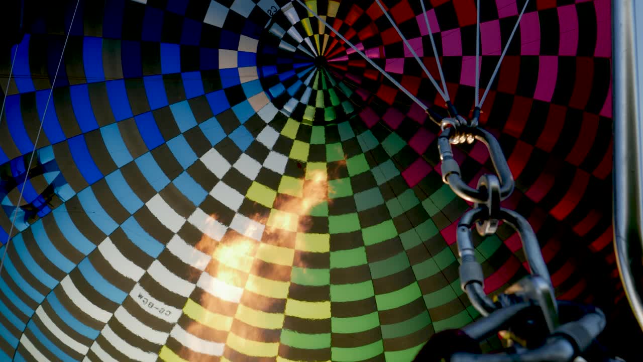 Inde i en farverig varmluftballon med flamme.