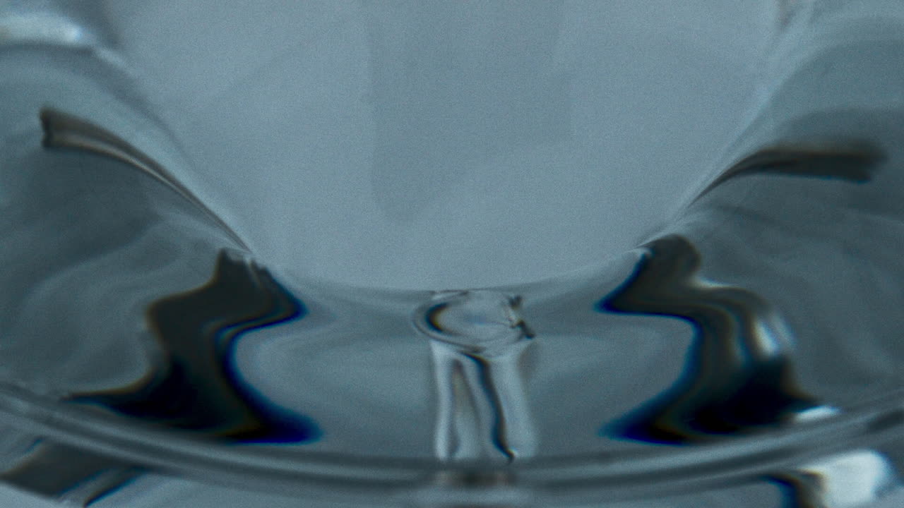 Ice cocktail created funnel inside glassware. Transparent aqua vortex in vessel