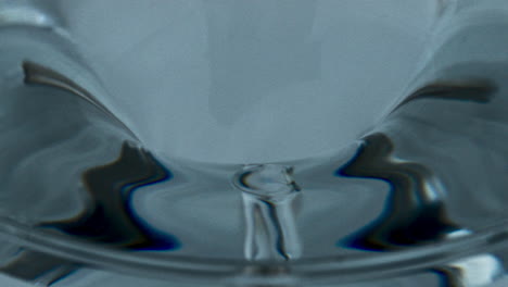 ice cocktail created funnel inside glassware. transparent aqua vortex in vessel