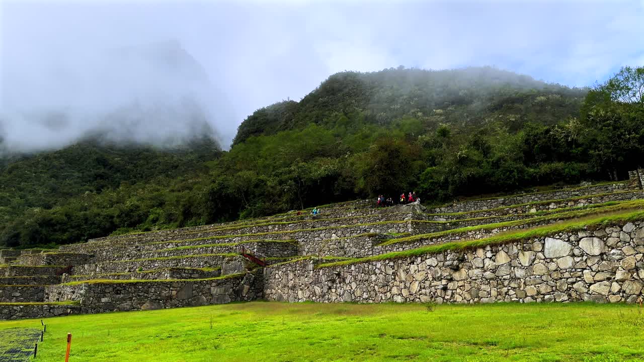 Poranny mglisty wschód słońca, szlak Inków, Machu Picchu, kamienne konstrukcje, trasa turystyczna, krajobraz, słoneczna mgła, chmury, peruwiańskie Andy, Peru, Perú, historyczne Sanktuarium Inków, świątynia, pora deszczowa, bujna zielona dżungla, ruch w lewo