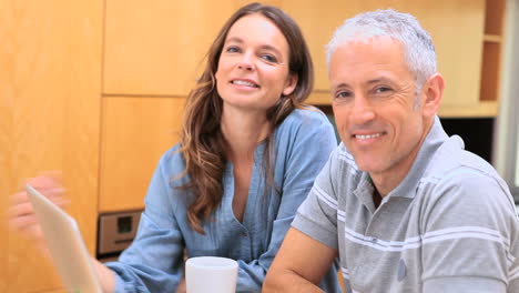 Smiling-couple-talking-in-front-of-a-laptop