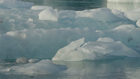 Glacier-Lagoon,-Jökulsárlón,-Iceland,-with-icebergs-and-flowing-icy-blue-water