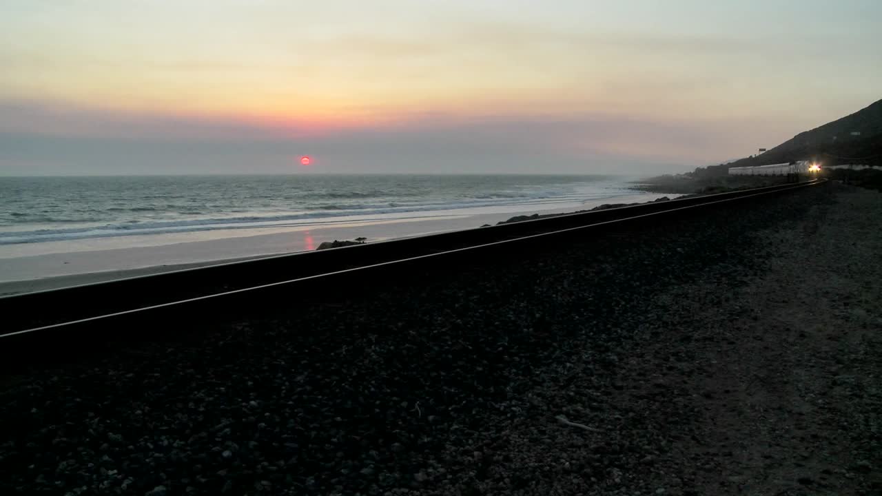 석양에 캘리포니아 해변을 지나가는 암트랙 열차의 아름다운 사진