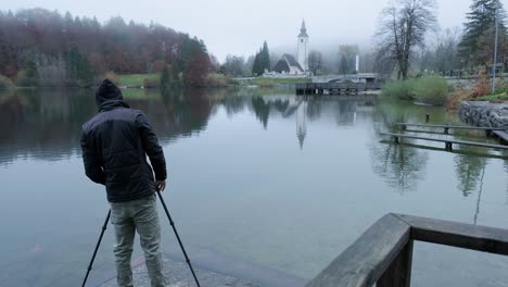 photographer setting up a tripod while wearing a black hoodie